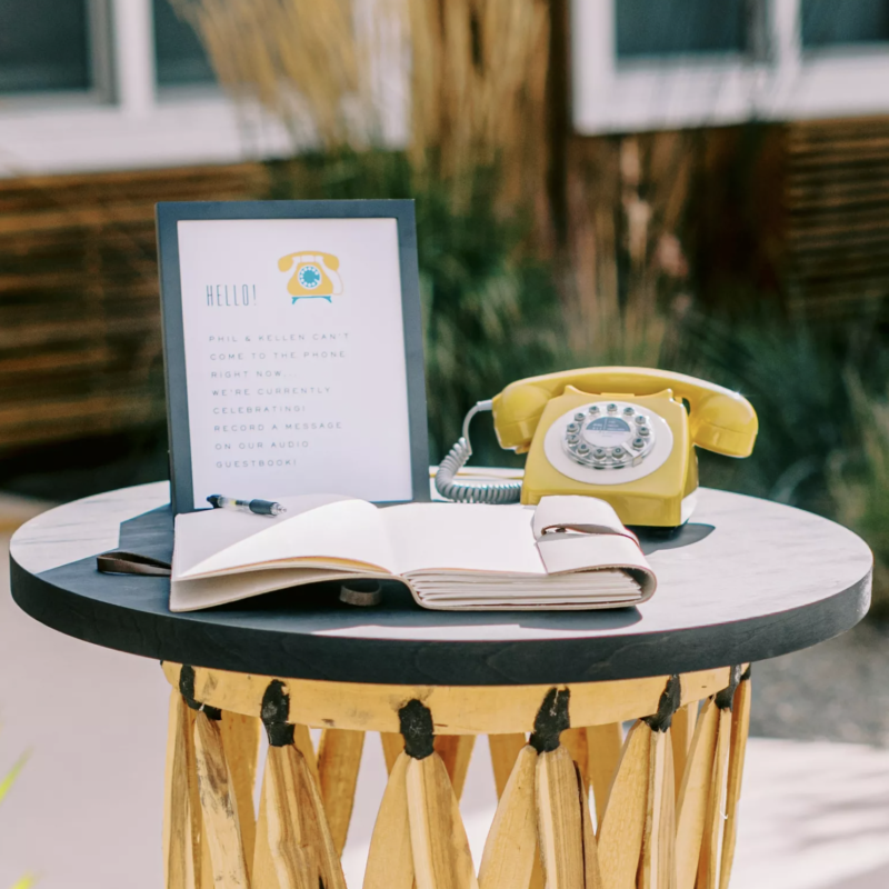 round table with yellow rotary phone audio guestbook