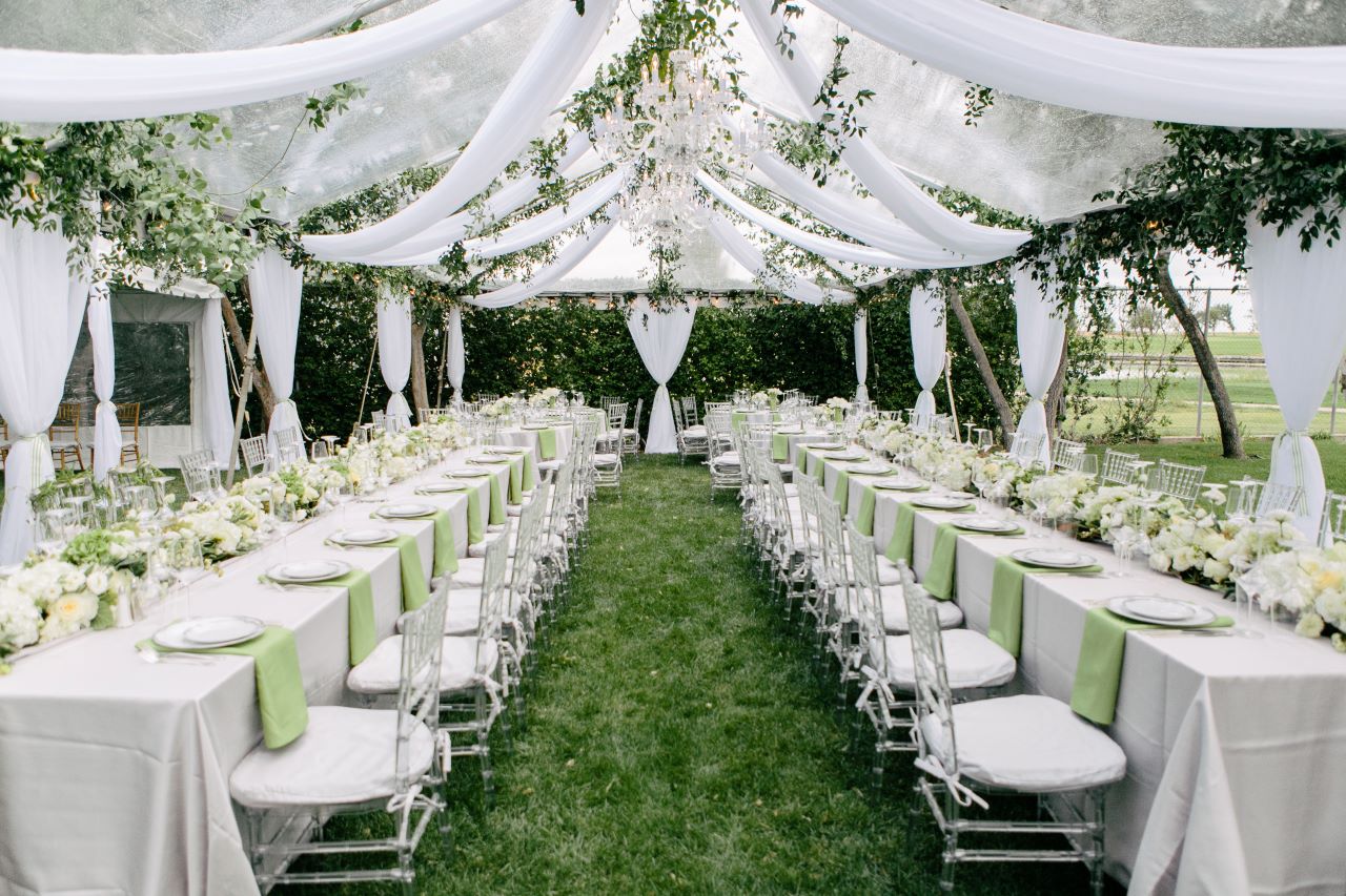 white and green wedding reception under draped ceiling